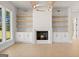 Living room with fireplace and built-ins featuring wood shelving and white cabinets at 3735 Tamiami Trl, Cumming, GA 30041