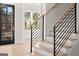Staircase with light wood treads, a light wood handrail, and black balusters are featured at 3735 Tamiami Trl, Cumming, GA 30041