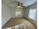 Neutral bedroom featuring a ceiling fan, natural light, and neutral carpet at 102 Crystal River Dr, Riverdale, GA 30274