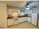 Bright kitchen with white cabinets, appliances and a ceiling fan with overhead lighting at 102 Crystal River Dr, Riverdale, GA 30274
