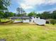 Expansive backyard featuring a storage shed, a large lawn, and privacy trees at 7340 Chalk Way, Riverdale, GA 30296