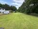Expansive backyard featuring a storage shed, a large lawn, and privacy trees at 7340 Chalk Way, Riverdale, GA 30296