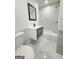 A stylish bathroom with marble-look floors and wall tiles, a floating vanity, and a tub with a shower at 7340 Chalk Way, Riverdale, GA 30296