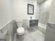 A bathroom features a toilet and a floating vanity with stylish storage drawers beneath a framed mirror at 7340 Chalk Way, Riverdale, GA 30296