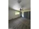 A carpeted bedroom with a ceiling fan and a window with natural light and gray trim at 7340 Chalk Way, Riverdale, GA 30296