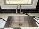Close-up of a stainless steel sink with a modern faucet and elegant countertop at 7340 Chalk Way, Riverdale, GA 30296