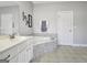 Bright bathroom featuring a tub with tile surround, vanity, and tiled floors at 315 Antebellum Way, Fayetteville, GA 30215