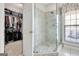 This bathroom offers a glass-enclosed shower, a window, and entry to a walk-in closet at 315 Antebellum Way, Fayetteville, GA 30215