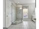 This bathroom has a glass-enclosed shower with a tiled floor, a window, and a door to a closet at 315 Antebellum Way, Fayetteville, GA 30215