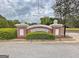 Community entrance sign with a brick base, attractive landscaping, and clear signage at 315 Antebellum Way, Fayetteville, GA 30215
