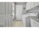 This laundry room features storage cabinets, a utility sink, and a window for natural light at 315 Antebellum Way, Fayetteville, GA 30215