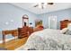 Well-lit main bedroom with hardwood floors, a ceiling fan, and a view into an ensuite bathroom at 315 Antebellum Way, Fayetteville, GA 30215