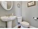 Cozy powder room featuring a pedestal sink, decorative mirror, and a neutral color scheme for a fresh look at 315 Antebellum Way, Fayetteville, GA 30215