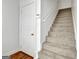 Carpeted staircase with white walls and trim plus a hardwood landing and adjacent white door at 315 Antebellum Way, Fayetteville, GA 30215