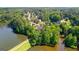 Aerial view of multiple homes and the lake, surrounded by a dense forest landscape at 255 Hidden Lake Dr, Fayetteville, GA 30215