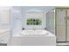 Bright bathroom features a large soaking tub under a window with a separate glass-enclosed shower at 255 Hidden Lake Dr, Fayetteville, GA 30215