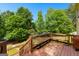 Wooden deck with a built in bench overlooking the surrounding wooded area and landscaped yard at 255 Hidden Lake Dr, Fayetteville, GA 30215