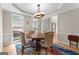 Bright dining room features natural light, stylish chandelier, round wood table and neutral color palette at 255 Hidden Lake Dr, Fayetteville, GA 30215