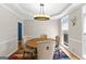 Bright dining room featuring a round wooden table, cushioned chairs, and a modern light fixture at 255 Hidden Lake Dr, Fayetteville, GA 30215