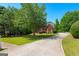 Long driveway leading to a red brick home with a well-maintained lawn and mature trees at 255 Hidden Lake Dr, Fayetteville, GA 30215
