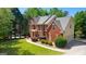 A view of the red brick exterior showcasing the home's architectural details and side-entry garage at 255 Hidden Lake Dr, Fayetteville, GA 30215