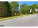Beautifully landscaped front yard with mature trees leading to a charming red brick home at 255 Hidden Lake Dr, Fayetteville, GA 30215
