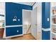 Inviting hallway featuring an open staircase, blue painted walls, and hardwood floors, creating a welcoming and stylish transition at 255 Hidden Lake Dr, Fayetteville, GA 30215