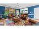 Bright living room showcasing blue walls, hardwood floors, leather furniture and natural light at 255 Hidden Lake Dr, Fayetteville, GA 30215