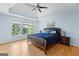 Spacious main bedroom with a tray ceiling, ceiling fan, and large window overlooking the backyard at 255 Hidden Lake Dr, Fayetteville, GA 30215