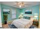 This staged bedroom features two matching tables, two nature paintings, a ceiling fan and a white bed at 1638 River Trc, Auburn, GA 30011