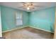 This bedroom is a light turquoise color with a window and carpeted floors and is completely empty at 1638 River Trc, Auburn, GA 30011