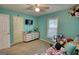 This bedroom features turquoise walls, a small TV, a ceiling fan and a dresser at 1638 River Trc, Auburn, GA 30011