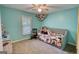This bedroom features a turquoise colored walls, with a window and a gray day bed and a ceiling fan at 1638 River Trc, Auburn, GA 30011