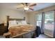 Well-lit bedroom featuring neutral tones, ceiling fan, and windows overlooking trees at 1638 River Trc, Auburn, GA 30011