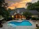 Aerial view of a beautiful home with a large pool, firepit and mature trees at 324 Chimney Sweep Cir, Peachtree City, GA 30269
