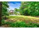 Secluded backyard with a pool and expansive lawn surrounded by mature trees at 324 Chimney Sweep Cir, Peachtree City, GA 30269