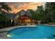 View of the backyard featuring large pool, patio area and lush landscaping at twilight at 324 Chimney Sweep Cir, Peachtree City, GA 30269