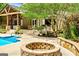 Backyard with covered deck, pool, patio, and stone fire pit feature at 324 Chimney Sweep Cir, Peachtree City, GA 30269
