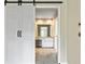Bathroom boasts white cabinets, granite countertops, and a stylish sliding barn door at 324 Chimney Sweep Cir, Peachtree City, GA 30269