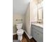 Charming half-bathroom features a vanity with a marble countertop, gray cabinets, and a decorative mirror at 324 Chimney Sweep Cir, Peachtree City, GA 30269