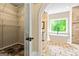A modern bathroom features a stand alone tub, large window, and view into the closet at 324 Chimney Sweep Cir, Peachtree City, GA 30269