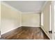 Empty bedroom with hardwood floors, neutral walls, white trim, and a window overlooking the backyard at 324 Chimney Sweep Cir, Peachtree City, GA 30269