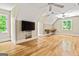 Bonus room features hardwood flooring, bright windows and built-in shelving with TV at 324 Chimney Sweep Cir, Peachtree City, GA 30269