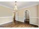 Dining room featuring hardwood floors, a chandelier, white trim, and arched doorways leading to other rooms at 324 Chimney Sweep Cir, Peachtree City, GA 30269