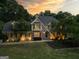 Exterior view of a home with stone accents and manicured landscaping illuminated in the evening light at 324 Chimney Sweep Cir, Peachtree City, GA 30269