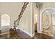 Inviting foyer featuring a staircase with a wrought iron railing and dark wood flooring and access to a half bathroom at 324 Chimney Sweep Cir, Peachtree City, GA 30269