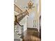 Spacious foyer featuring hardwood floors, a chandelier, a staircase with iron railings, and a front door with a window at 324 Chimney Sweep Cir, Peachtree City, GA 30269