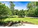 Beautifully landscaped front yard with green lawn, mature trees, and circular driveway at 324 Chimney Sweep Cir, Peachtree City, GA 30269