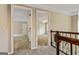 Upstairs hallway featuring neutral walls and carpet, white trim, and views into bedrooms with carpet and ceiling fans at 324 Chimney Sweep Cir, Peachtree City, GA 30269