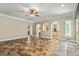 Open living space with tile floors, arched doorways, and a view into the kitchen area with white cabinets at 324 Chimney Sweep Cir, Peachtree City, GA 30269